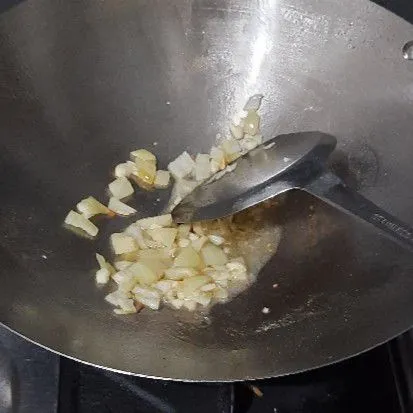 Tumis bawang putih dan bombai hingga layu.