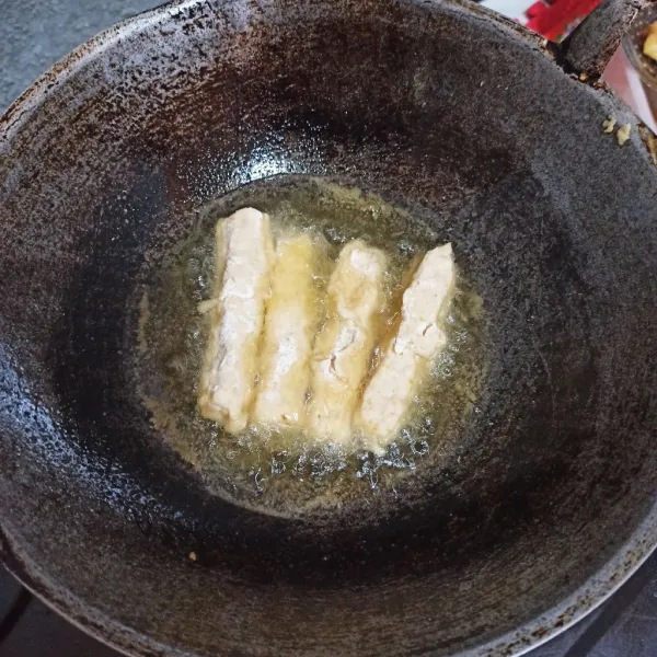 Panaskan minyak, kibaskan tempe, goreng hingga berubah warna.