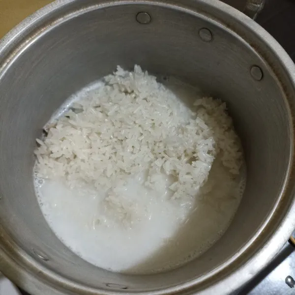 Tuang beras ketan kukus ke dalam santan. Aduk merata dan biarkan santan meresap ke dalam beras ketannya.