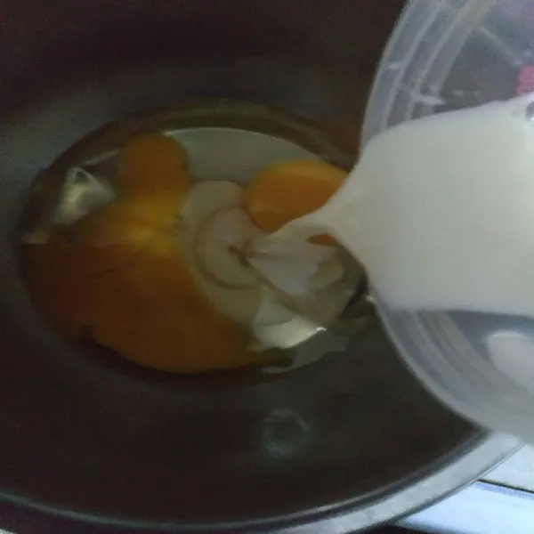 Masukkan susu full cream ke dalam wadah berisi telur