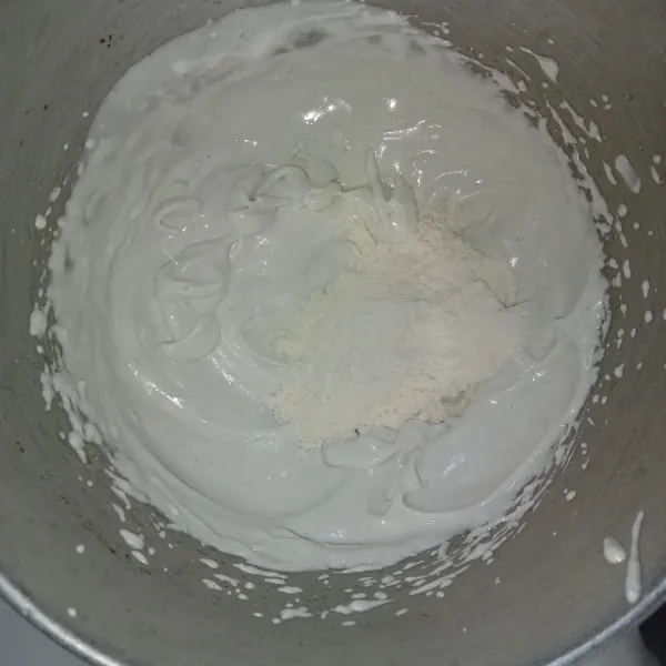 Masukkan campuran tepung dan gula halus ke dalam adonan putih telur tadi, kemudian aduk balik perlahan.