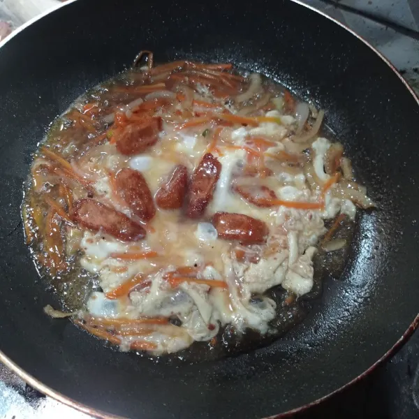 Tuang air, kecap asin dan saus teriyaki masak sampai mendidih, tes rasa lalu tuang telur dan masukan nugget.