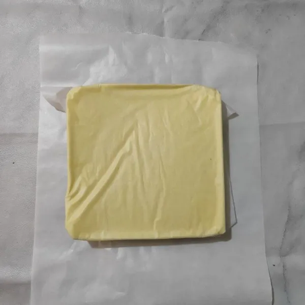 Keluarkan cake dari loyang, letakkan diatas kertas roti yang ukurannya lebih besar.