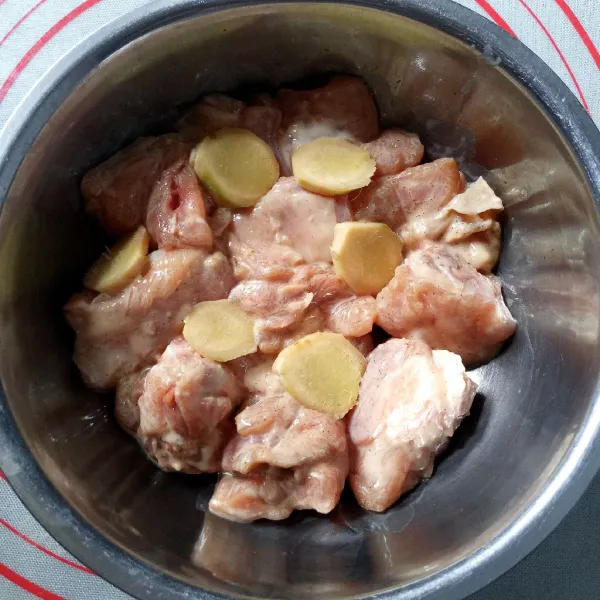 Siapkan wadah stainless, tata sebagian irisan jahe kemudian timpa dengan potongan ayam, tata sisa irisan jahe diatas ayam.