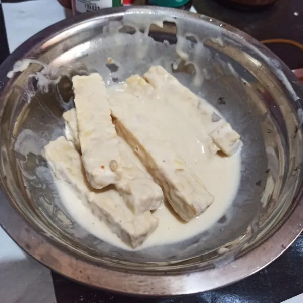 Ambil 2 sdm tepung bumbu lalu beri air, rendam tempe 5 menit.
