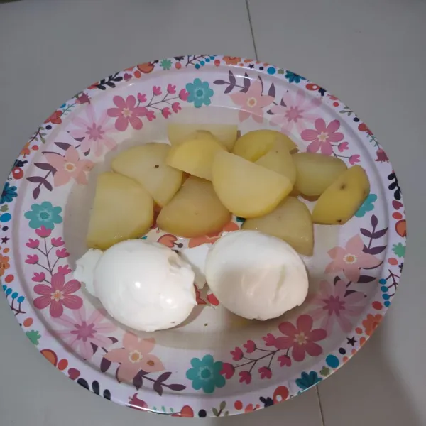 Kupas telur dan potong kentang rebus.
