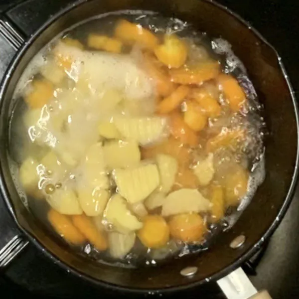 Didihkan air & rebus makaroni, wortel & kentang sampai empuk
