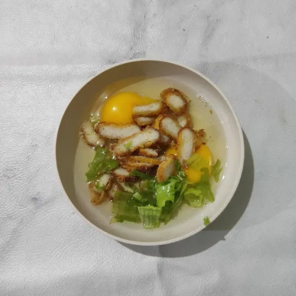 Masukkan telur, potongan nugget ayam dan daun bawang dalam wadah.