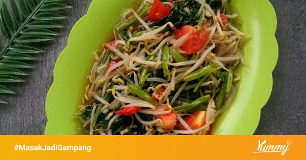 Oseng kangkung tahu dalam piring saji dengan latar belakang meja makan