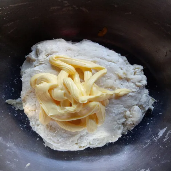 Setelah itu masukkan mentega putih, uleni lagi dengan tangan selama 15 menit hingga adonan kalis dan tidak lengket lagi di tangan.