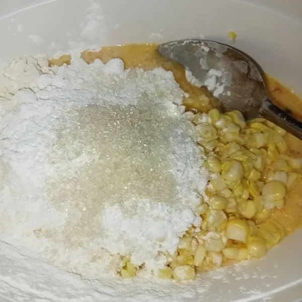 Masukkan jagung halus ke dalam wadah, masukkan setengah bagian jagung sisanya, tambahkan tepung terigu, tapioka, gula, garam dan kaldu jamur.