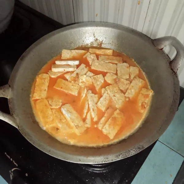 Masukan potongan tempe kedalam bumbu, aduk-aduk hingga tercampur merata, tunggu sampai tempenya matang, dan airnya sedikit menyusut.