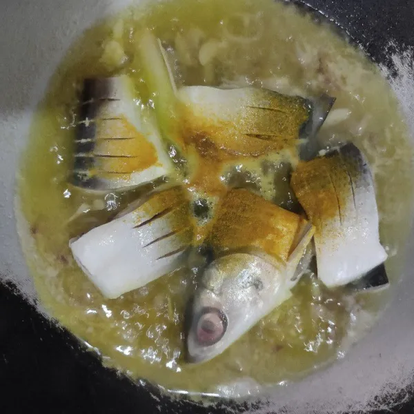 Tambahkan air dan air asam jawa lalu masukkan ikan bandeng dan kunyit bubuk lalu masak hingga mendidih.