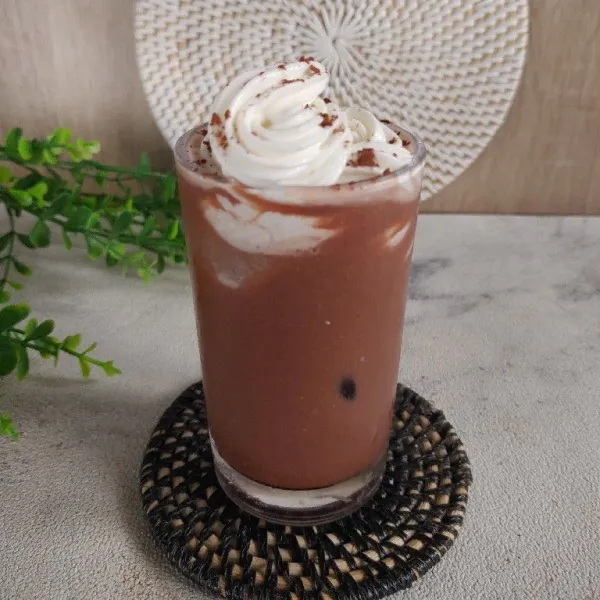 Kalau mau lebih dingin, tambahkan es batu didasar gelas tuang milkshake beri toping whipping cream dan cokelat bubuk.