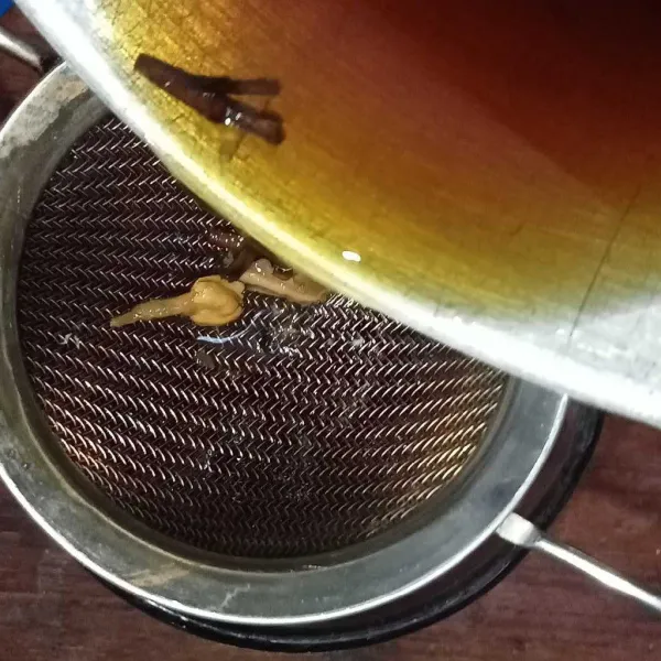 Saring teh ke dalam gelas.