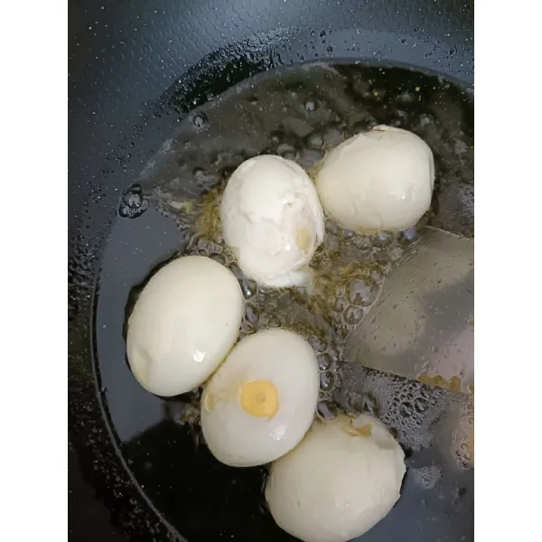 Rebus telur lalu kupas dan goreng
