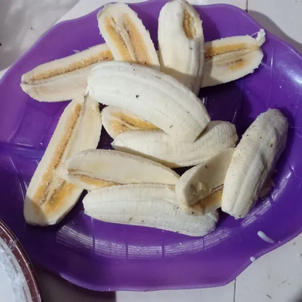 Kupas pisang lalu belah dua