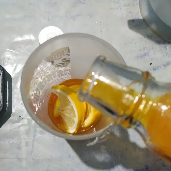 Masukkan sirup orange squash ke dalam gelas.
