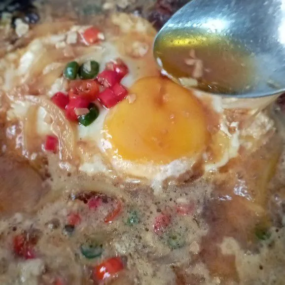 Aduk sambil siram kuah  dan bumbu di atas telur.
