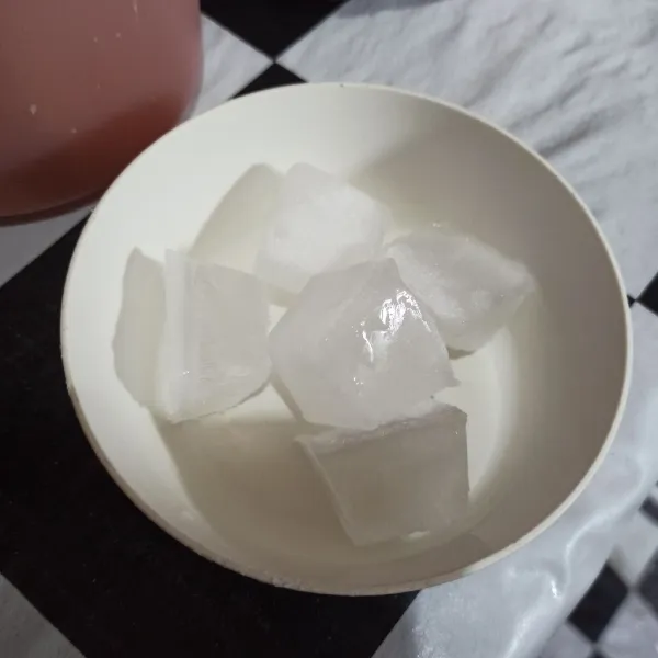 Letakkan es batu di wadah.