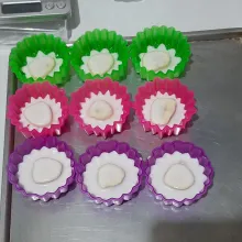 Siapkan cetakan, olesi dengan minyak goreng kemudian letakkan 1 potong pisang pas di tengah, kemudian tuang dengan 2 sdm adonan kukus 5 menit