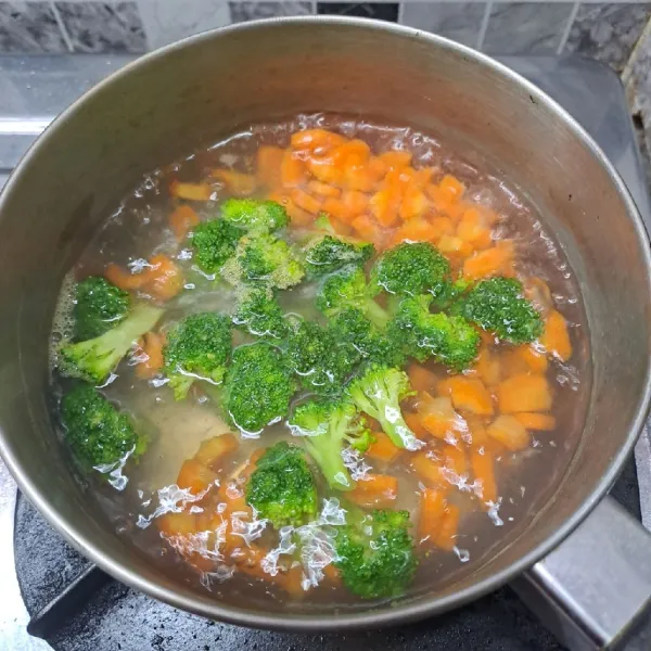 Rebus air sampai mendidih. Masukkan brokoli dan wortel, masak sampai ½ matang. Angkat dan tiriskan.