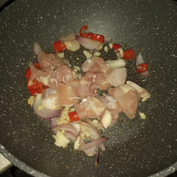 Sangrai bawang putih, bawang bombay, jahe dan cabe merah. Setelah kelihatan layu tuang sedikit air. Masak sampai air habis. Masukkan ayam, masak sampai berubah warna.