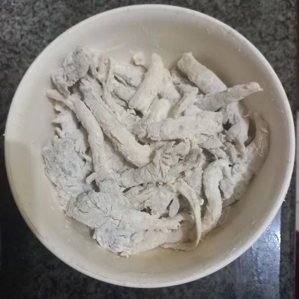 Gulingkan jamur pada adonan tepung kering, ratakan.