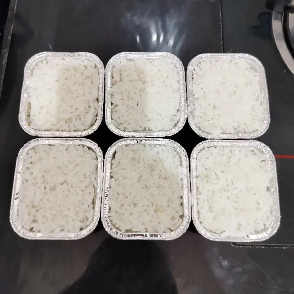 Setelah itu masukkan nasi di atasnya hingga cup penuh sambil dipadatkan. Lalu tuang sisa air kaldu di atas nasi.