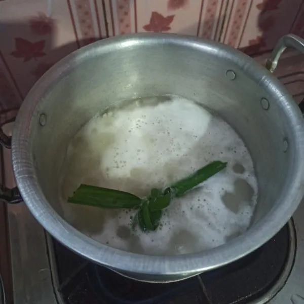 Cuci bersih beras kemudian tambahkan air dan daun pandan lalu rebus sampai mendidih.