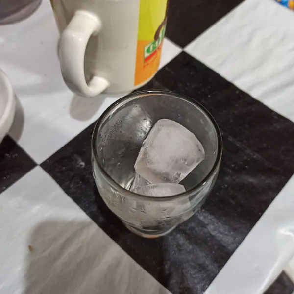 Letakkan es batu ke gelas saji.