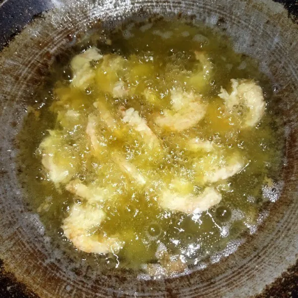 Lalu kibaskan udang, goreng dalam minyak yang sudah panas, goreng hingga matang, lalu angkat.