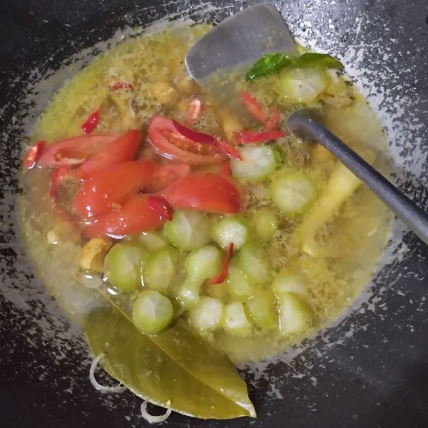 Tuang air dan biarkan hingga ayam empuk lalu masukkan tomat, cabai dan belimbing wuluh.