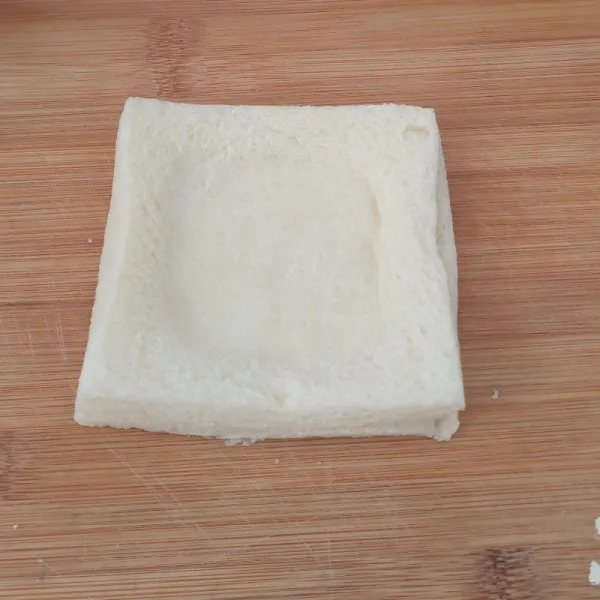 Tumpuk roti jadi satu, lalu buat lengkungan di tengahnya dengan batuan sendok atau jari.