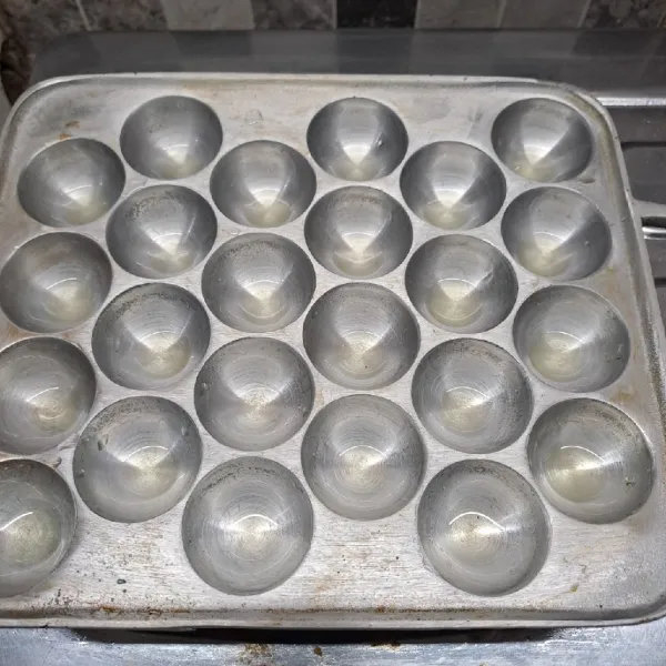 Panaskan cetakan takoyaki dengan sedikit olesan minyak goreng.