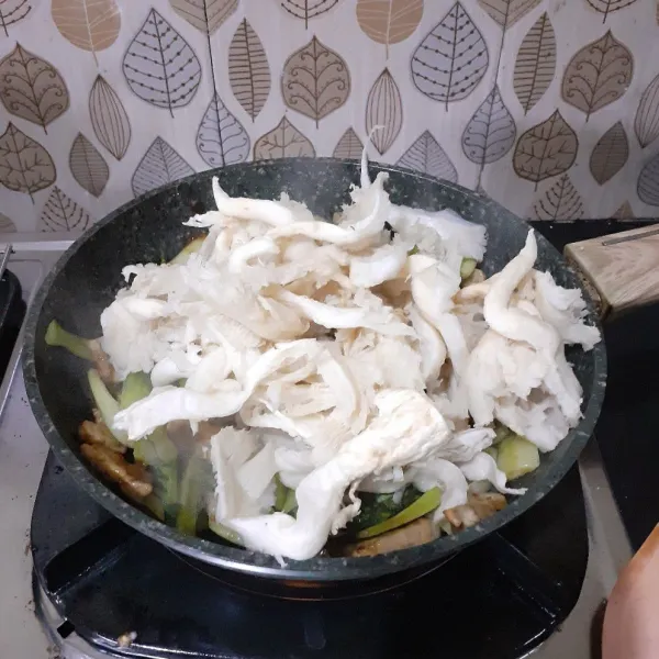 Masukkan jamur tiram, aduk rata, masak sampai layu.