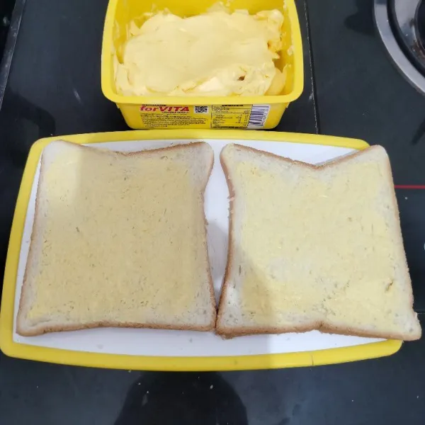 Lalu oles salah satu sisi roti dengan margarin hingga rata.