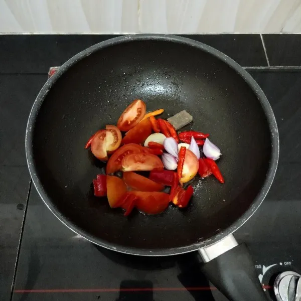 Panaskan sedikit minyak. Goreng cabai besar, cabai rawit, bawang merah, bawang putih, tomat dan terasi hingga layu. Lalu angkat.