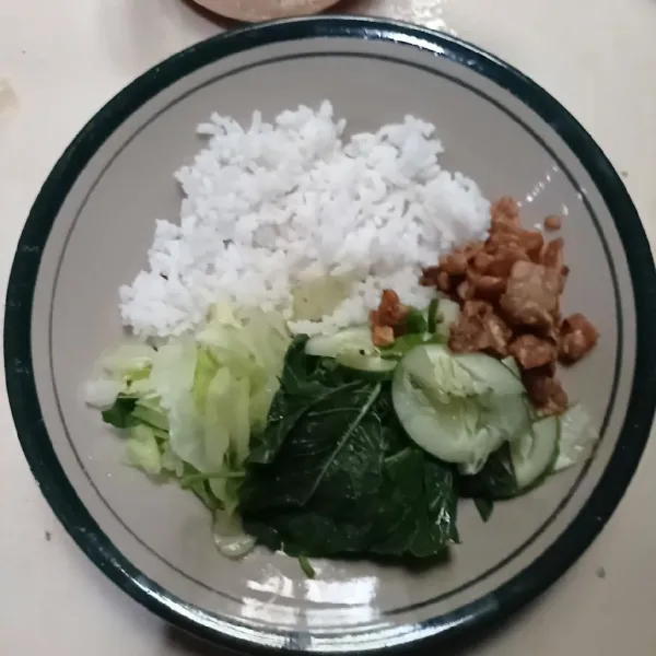 Siapkan nasi, beri sayuran, tempe dan timun.