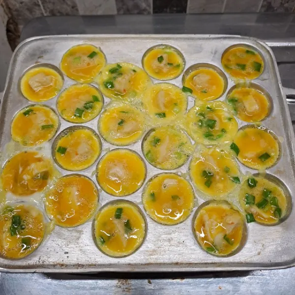 Tuang adonan telur dengan 1 lubang 1 potongan fish roll. Masak sampai matang di kedua sisi. Angkat dan sajikan dengan ditusuk seperti sate.