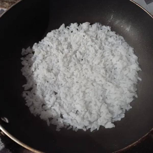 Panaskan teflon, lalu tuang nasi ratakan sampai rata.