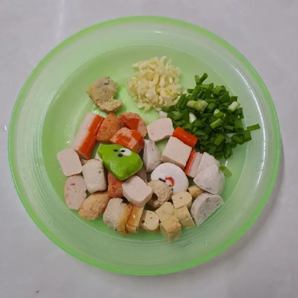 Cincang bawang putih, geprek jahe, potong kasar daun bawang dan potong-potong aneka bakso ikan.