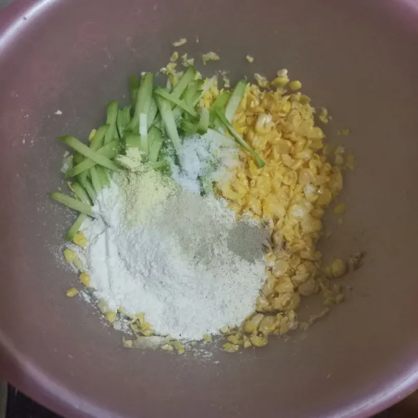 Dalam wadah campur jagung, labu siam, tepung terigu, garam, kaldu jamur, bawang putih bubuk dan merica bubuk, aduk rata.