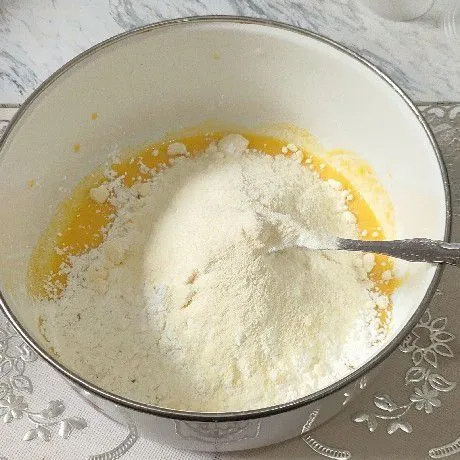 Masukkan tepung maizena dan susu bubuk, aduk rata. Jika masih belum membentuk adonan, beri secukupnya putih telur.