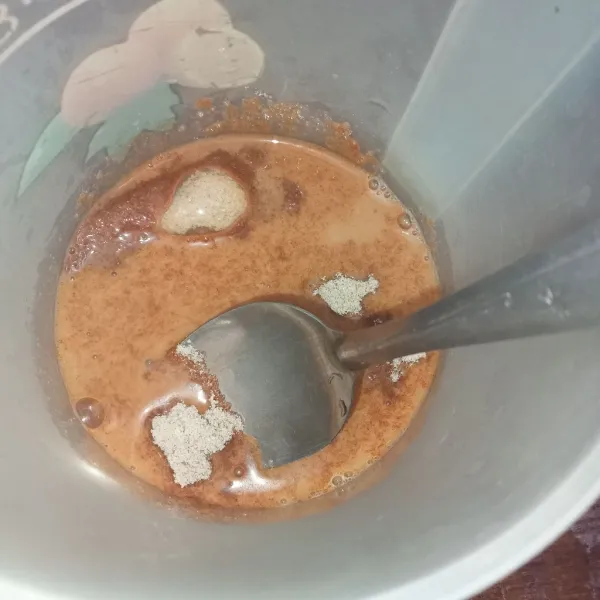 Tuang air panas ke dalam gelas berisi thai tea powder dan gula, aduk rata.