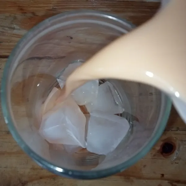 Kemudian tuang thai tea ke dalam gelas saji berisi es batu. Sajikan.