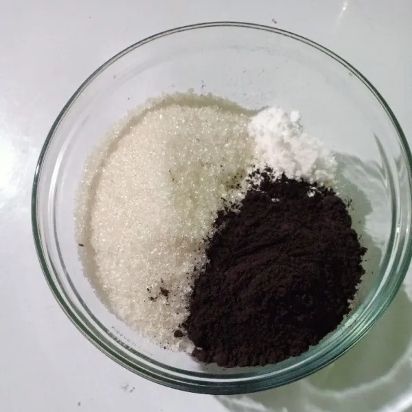 Dalam wadah masukkan tepung terigu, gula pasir, baking soda, vanili, dark coklat bubuk dan garam. Aduk hingga tercampur rata.