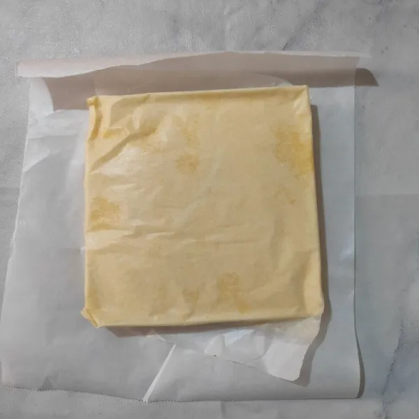 Setelah matang, keluarkan cake dari loyang dan biarkan hangat, lalu letakkan cake di atas baking paper yang ukurannya lebih besar.