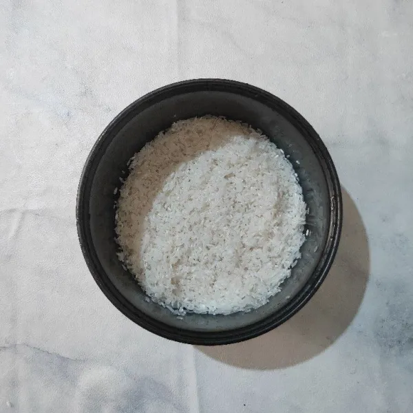 Cuci bersih beras, kemudian masukkan dalam wadah.