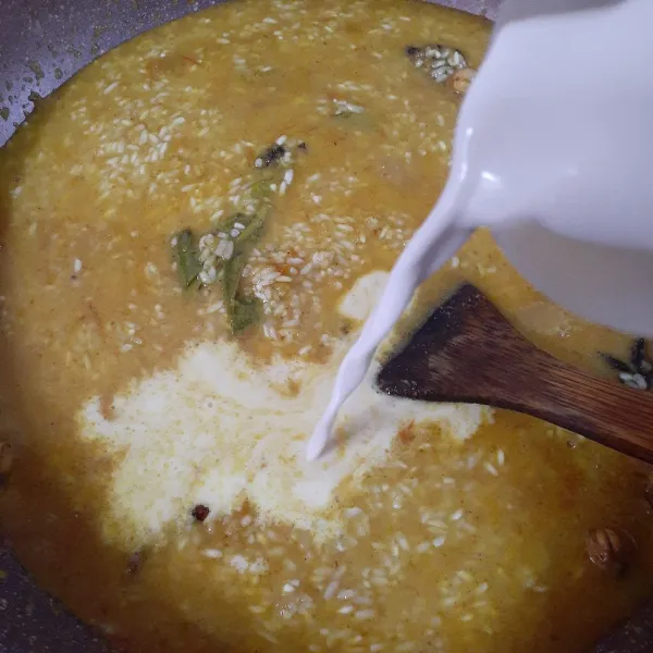 Tuangkan santan encer serta santan kental, aduk rata. Tambahkan penyedap dan garam halus, aduk rata.